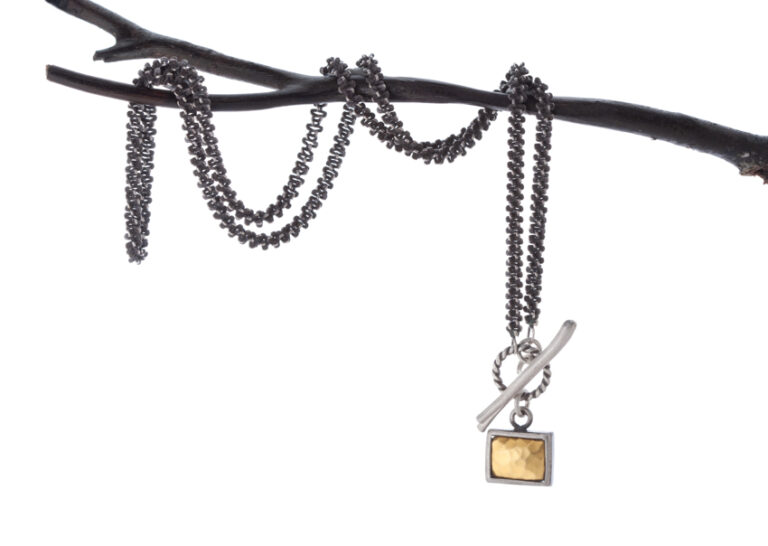 Silver and gold necklace on a branch by Claudia Kussano photo by @PernillaPersson.com